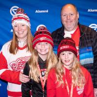 Group of four posing for photo in front of GVSU Alumni backdrop